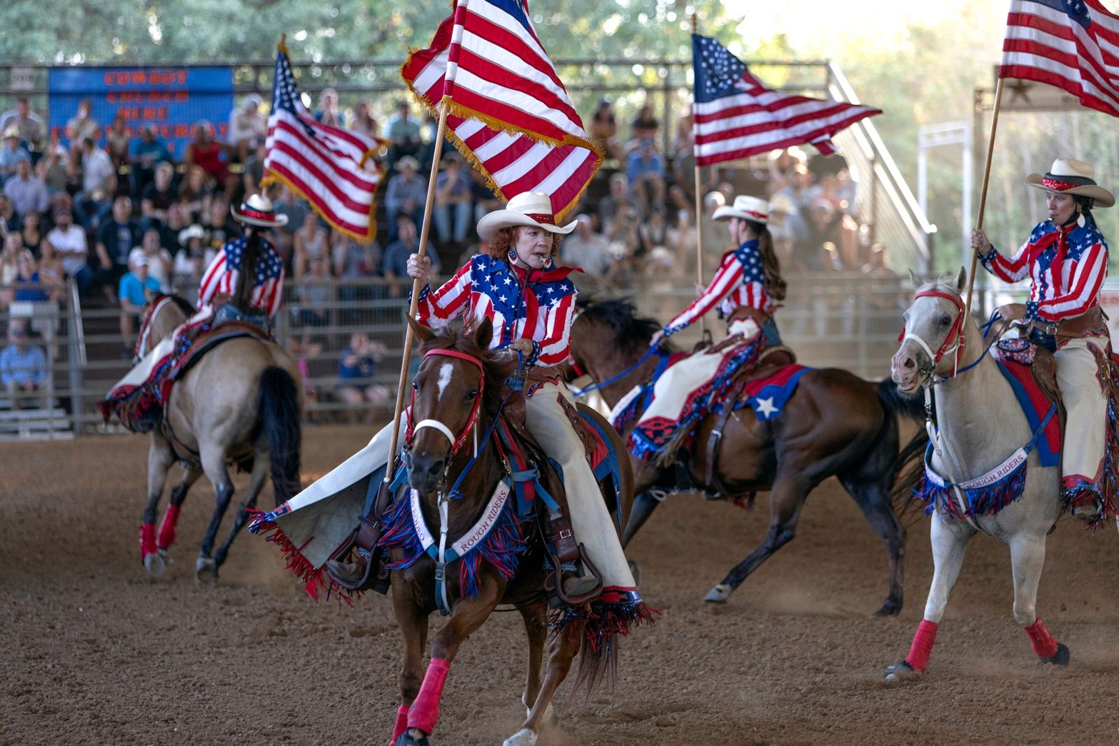 Rider standing on horse holding a US flag